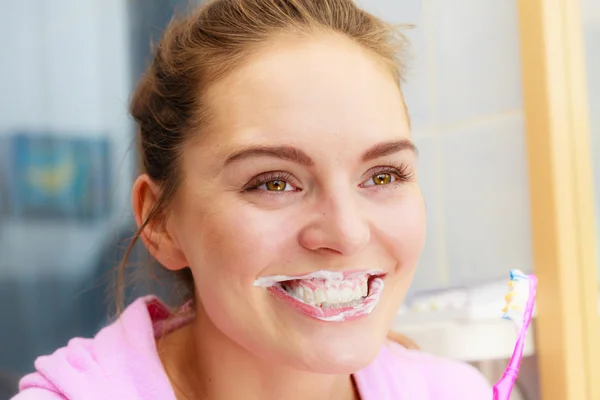 Mujer cepillarse los dientes de limpieza en el baño — Foto de Stock