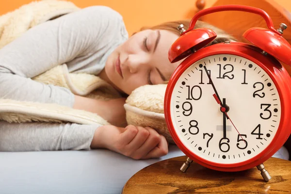 Mujer durmiendo en la cama con reloj despertador . —  Fotos de Stock