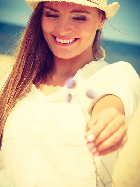 Leende flicka med blomma på stranden — Stockfoto