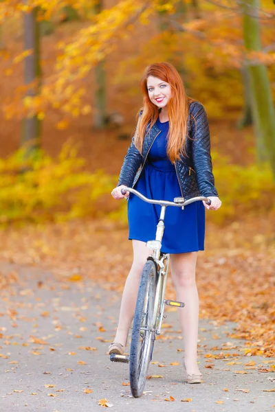 赤毛の女性が公園でサイクリング. — ストック写真