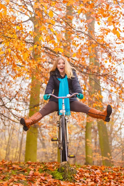 Mujer activa que se divierte montando bicicleta en el parque de otoño —  Fotos de Stock