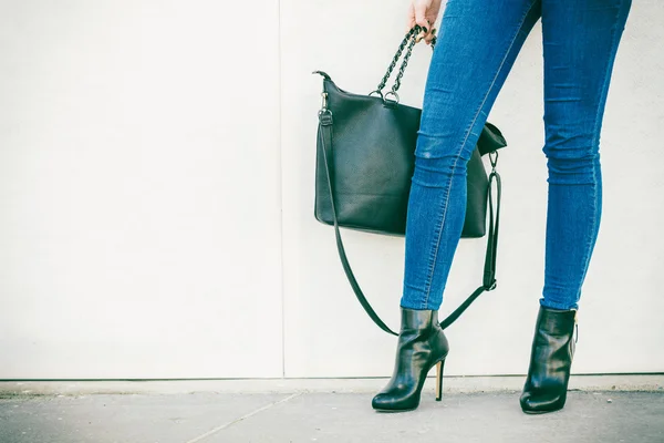 Piernas de mujer en zapatos de tacón bolso en mano — Foto de Stock