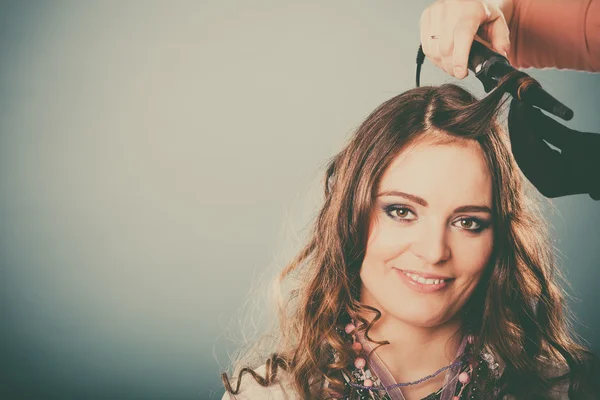 Cabeleireiro curling cabelo mulher com frisador de ferro. — Fotografia de Stock