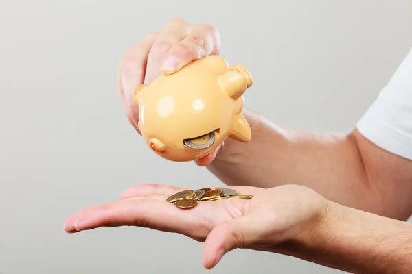 Male hands with coins and piggybank — Stock Photo, Image