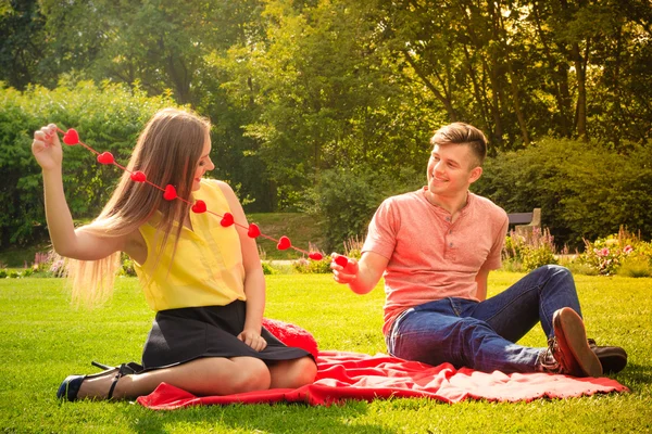 Couple with hearts necklace on picnic — Stock Photo, Image