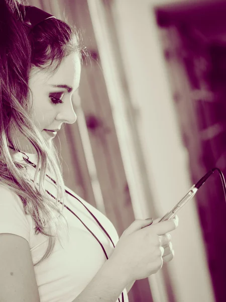 Vrouw met hoofdtelefoon Kies muziek op smartphone. — Stockfoto