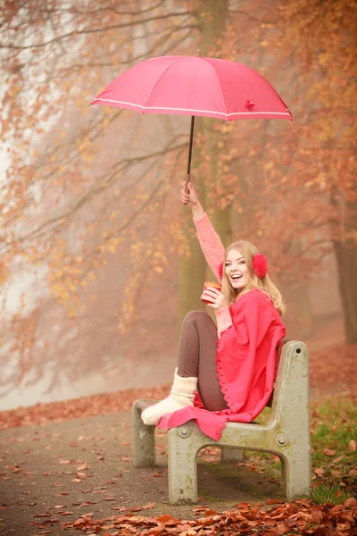 Girl sitting in park with umbrella — Stock Photo, Image