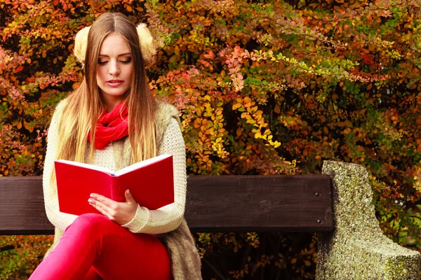 Frau entspannt sich im herbstlichen Park beim Lesen von Buch — Stockfoto