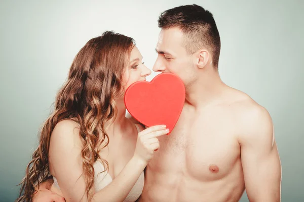 Loving couple kissing behind red heart. Love. — Stock Photo, Image