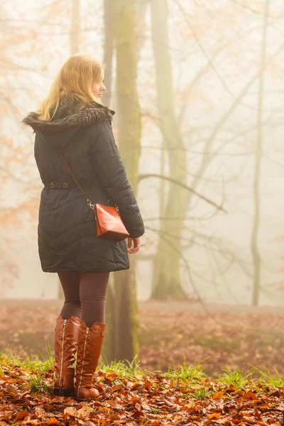 Donna che cammina nel parco in giorno nebbioso — Foto Stock