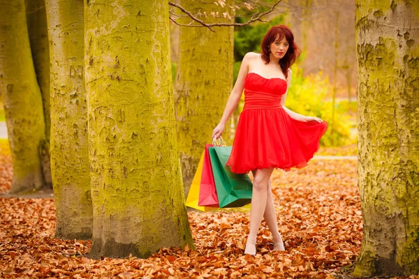 Autumn shopper woman with sale bags outdoor in park — Stock Photo, Image