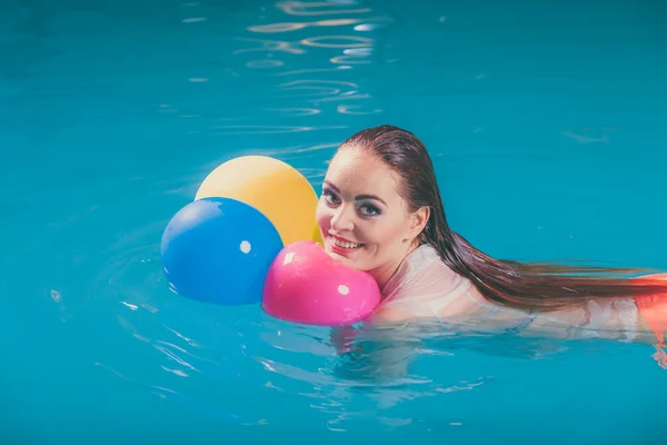 Glückliche Frau im Wasser hat Spaß mit Luftballons — Stockfoto