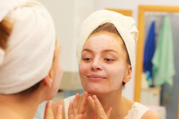 Donna che applica crema maschera sul viso in bagno — Foto Stock