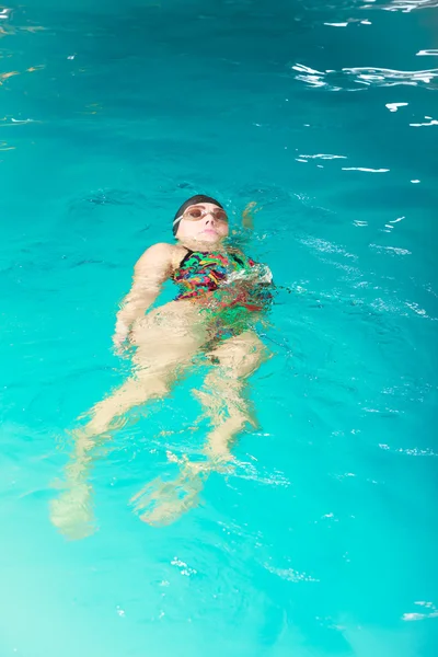 Woman athlete swimming backstroke in pool. — Stock fotografie