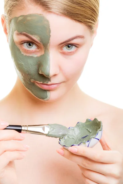 Menina aplicando máscara de barro facial em seu rosto — Fotografia de Stock