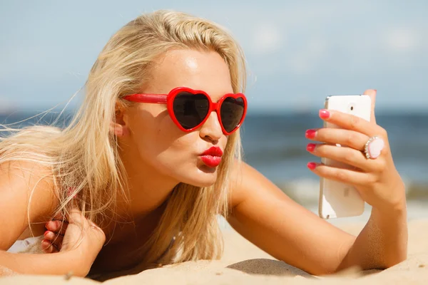 Mujer acostada en la playa de arena usando el teléfono celular —  Fotos de Stock