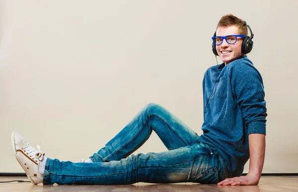 헤드폰을 가지고 바닥에 앉아 있는 젊은이 — 스톡 사진