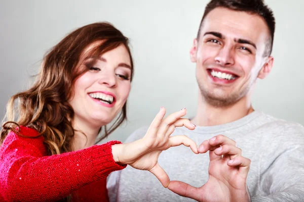 Jeune couple faisant forme de coeur par les mains — Photo