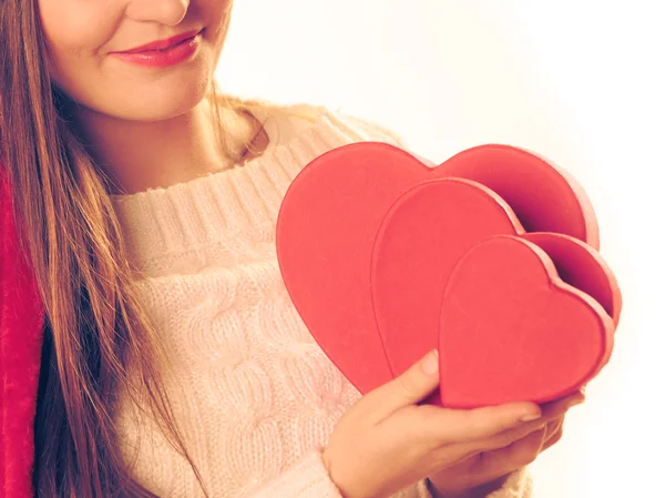 Girl holds heart shaped gift boxes — Stock Photo, Image