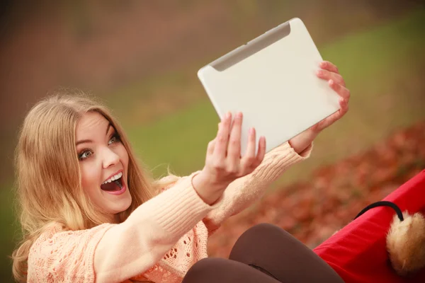 Menina sentada no banco com tablet . — Fotografia de Stock