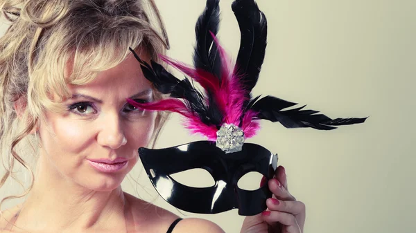 Kadın orta yaşlı karnaval maskesi tutar. — Stok fotoğraf