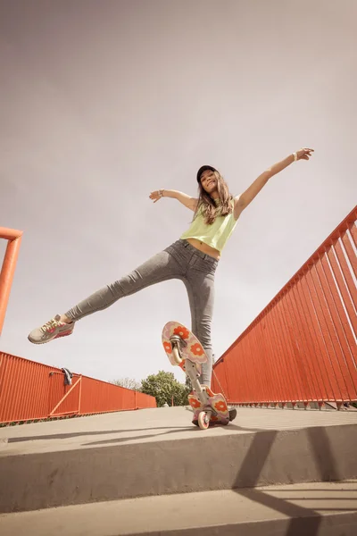 Dospívající dívka bruslař na koni skateboard na ulici. — Stock fotografie