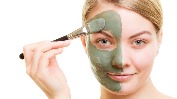 Vrouw aanbrengen met borstel klei modder masker haar gezicht — Stockfoto