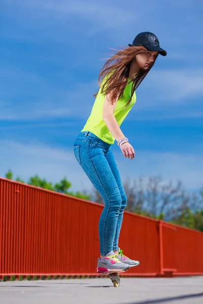 Dospívající dívka bruslař na koni skateboard na ulici. — Stock fotografie