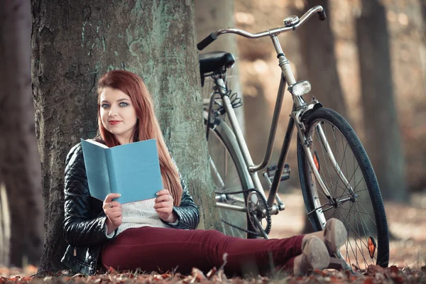 Egy nő könyvet olvas a fa alatt — Stock Fotó