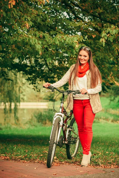 Mädchen entspannt sich im herbstlichen Park mit Fahrrad. — Stockfoto