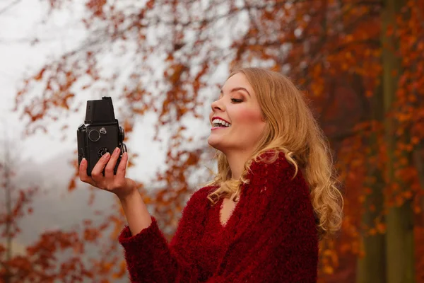 Woman with old vintage camera taking selfie photo. — Stockfoto