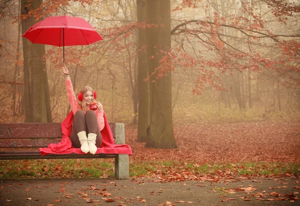 Flickan sitter i parken med paraply — Stockfoto