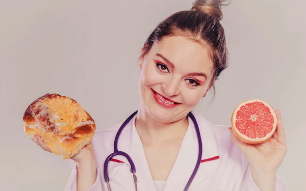 Dietitian with sweet roll bun and grapefruit. — Stock Photo, Image