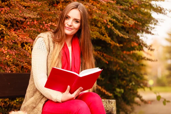 Frau entspannt sich im herbstlichen Park beim Lesen von Buch — Stockfoto