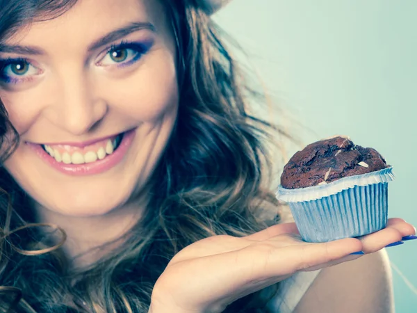 Smiling woman holds chocolate cake in hand — Stock Photo, Image