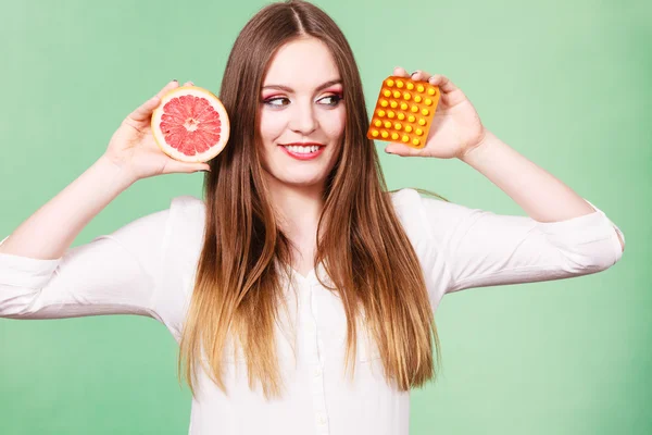 Vrouw houdt van grapefruit en blister pack vitamine c pillen — Stockfoto