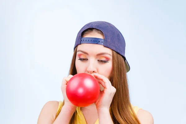 Femmina adolescente gonfiaggio palloncino rosso . — Foto Stock