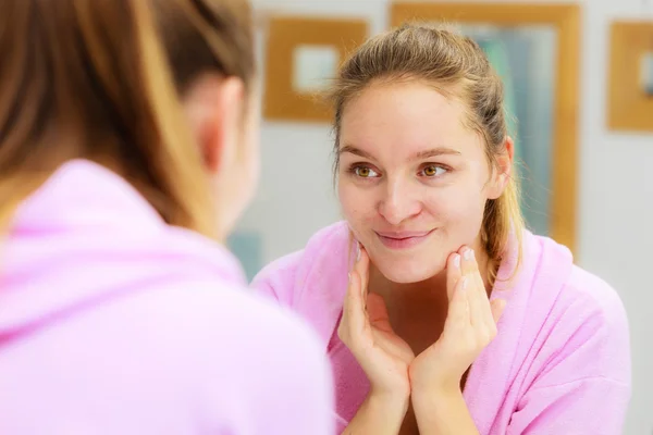 Kvinna rengöring hennes ansikte med scrub i badrum. — Stockfoto