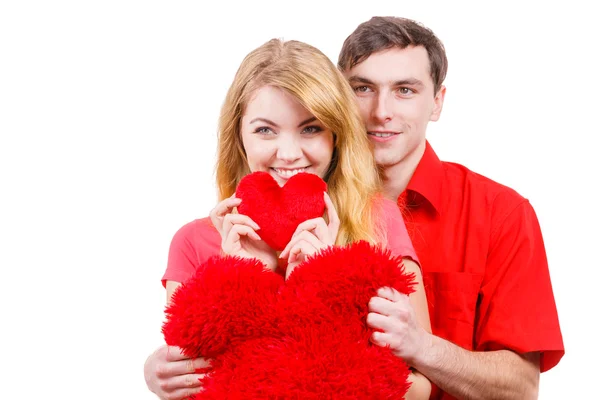 Casal detém vermelho coração em forma de travesseiros símbolo do amor — Fotografia de Stock