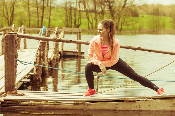 Chica de entrenamiento en ropa deportiva en la orilla del lago — Foto de Stock