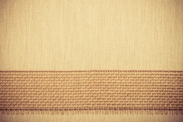 Jute ribbon on linen cloth background — Stock Photo, Image