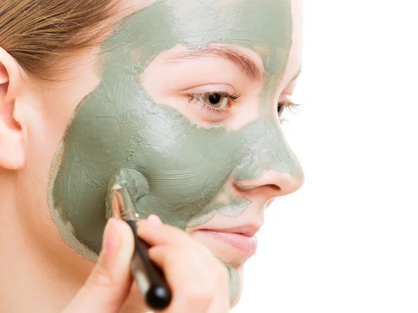 Vrouw aanbrengen met borstel klei modder masker haar gezicht — Stockfoto