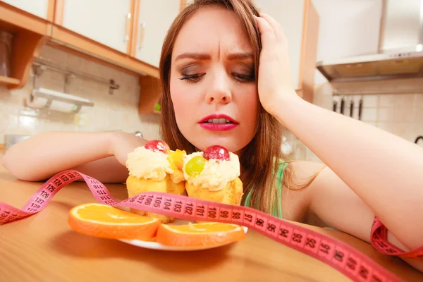Woman with tape measure and cake. Diet dilemma. — Stock Photo, Image