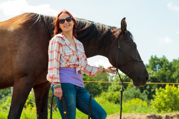 Jonge vrouw meisje het verzorgen van het paard. — Stockfoto