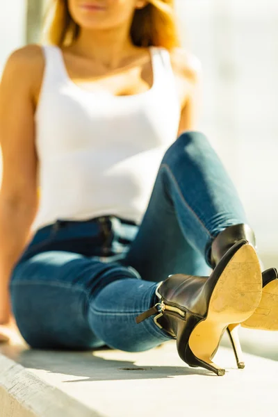 Mulher de calça jeans sapatos de salto ao ar livre — Fotografia de Stock