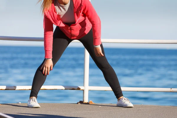 Mulher fazendo exercícios esportivos ao ar livre à beira-mar — Fotografia de Stock