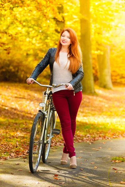 Chica de belleza relajante en el parque de otoño con bicicleta, al aire libre — Foto de Stock