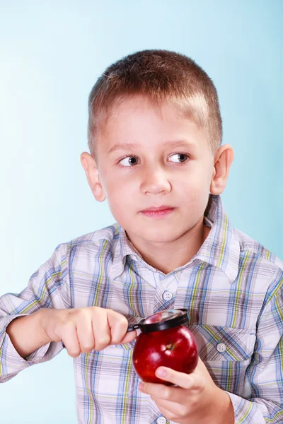 Kid examine apple with magnifying glass. — Stock Photo, Image