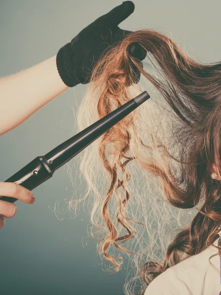 Cabeleireiro curling cabelo mulher com frisador de ferro. — Fotografia de Stock