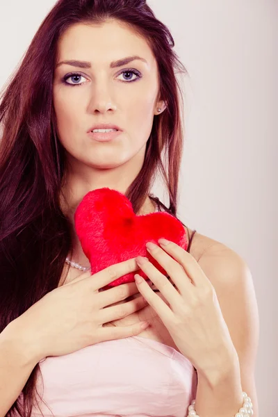 Schöne Frau hält rotes Herz — Stockfoto